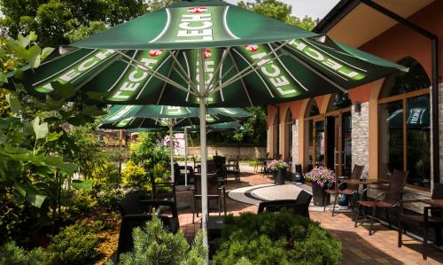 a large green umbrella in front of a restaurant at Złote Arkady in Częstochowa
