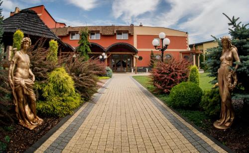 a building with statues in front of a walkway at Złote Arkady in Częstochowa