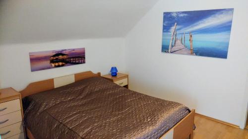 a bedroom with a bed and two pictures on the wall at Apartments Ina in Rogaška Slatina