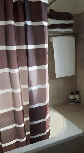 a bathroom with a shower curtain and a sink at Agrepavli Lapithia in Kallepia