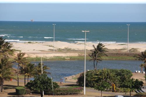 a beach with palm trees and a body of water at Aquarios Praia Hotel in Aracaju