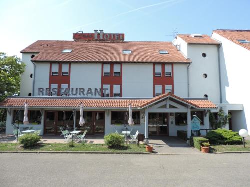 a hotel with a red and white building at Logis Cris Hôtel, Lyon Est in Corbas