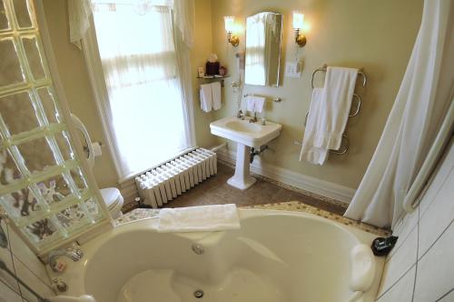 a bathroom with a large tub and a sink at The Oliver Inn in South Bend