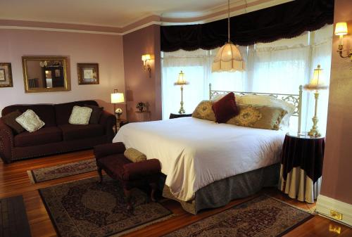 a bedroom with a bed and a couch at The Oliver Inn in South Bend