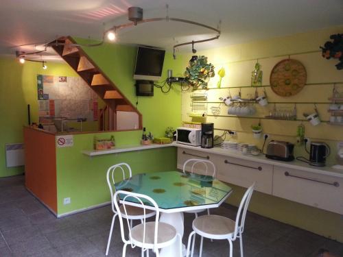 a kitchen with a table and chairs in a room at Chambres d'Hôtes Au Grillon Dort in Moustey