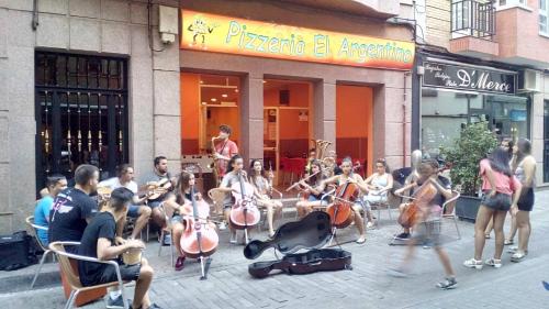 a group of people playing instruments on a street at Caminito ARG in La Bañeza