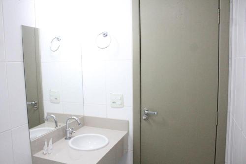 uma casa de banho com um lavatório e um espelho em Excellence Comfort Hotel em Divinópolis