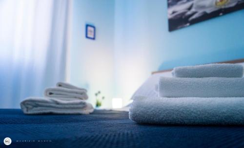 una pila de toallas sentadas encima de una cama en B&B Interno 8 en Roma