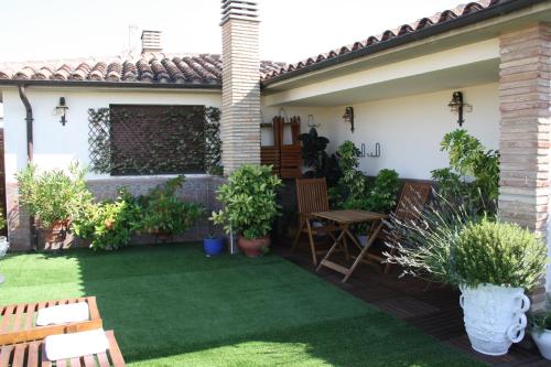 a backyard with a patio with grass and plants at Hotel Merindad de Olite in Olite