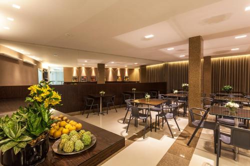 un restaurante con mesas, sillas y frutas en la mesa en Leopoldo Hotel, en Guanambi