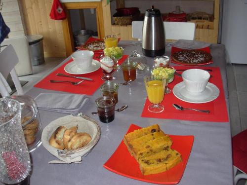Una mesa con servilletas rojas y comida encima. en Le Jardin des Pierres Brunes, en Saint-Jean-des-Ollières