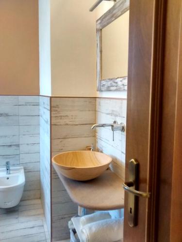 a bathroom with a wooden bowl sink and a mirror at La Pomella in Ponte Nizza