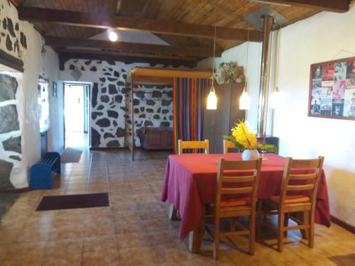 a dining room with a red table and chairs at Casa Farrobo in Horta
