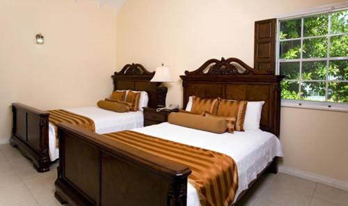 a bedroom with two beds and a window at Villa Beach Cottages in Castries