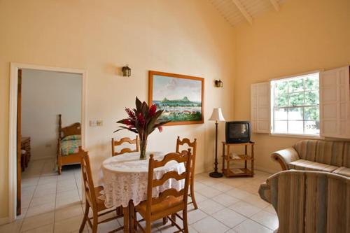 a living room with a table and a couch at Villa Beach Cottages in Castries