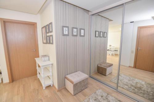 a room with a glass shower with a stool and a door at IN24 in Palanga
