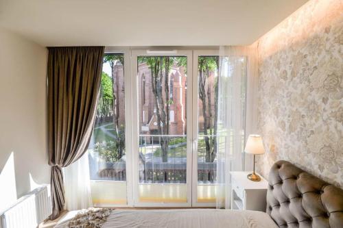 a bedroom with a bed and a large window at IN24 in Palanga