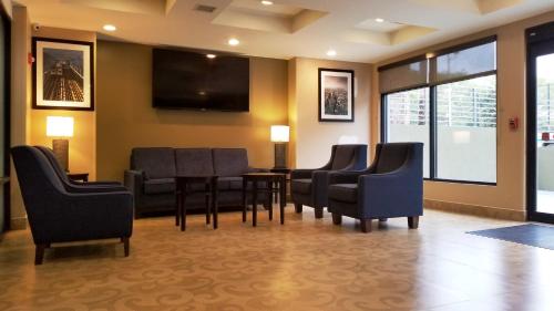 a waiting room with chairs and a table and a tv at Days Inn by Wyndham Brooklyn Marine Park in Brooklyn