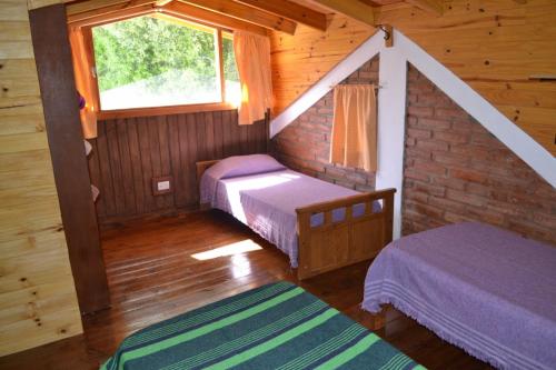 sypialnia z 2 łóżkami w drewnianym domku w obiekcie Los Maitenes Bariloche w mieście Bariloche