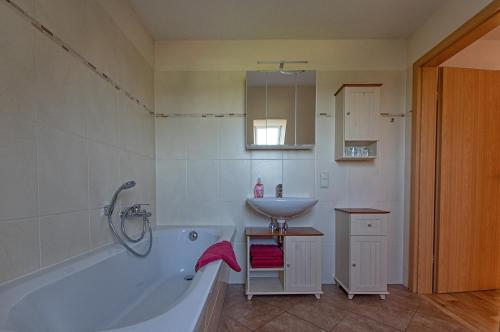 a bathroom with a white tub and a sink at Gastwirtschaft & Hotel Hallescher Anger in Naumburg