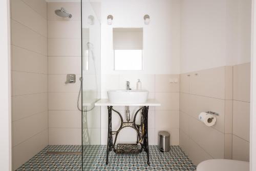 a bathroom with a sink and a glass shower at Ava Apartamenty in Niechorze