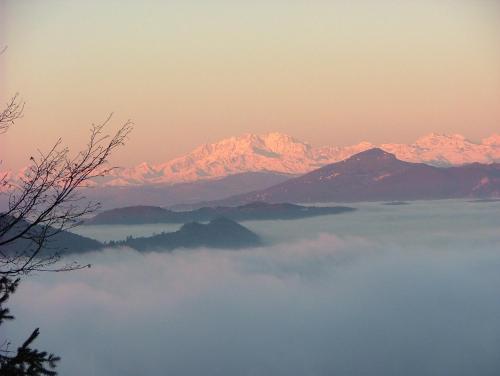 a view of a mountain range with a layer of clouds at Baita Sorriso in Brunate
