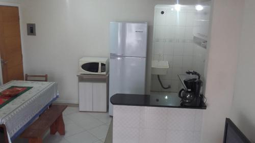una pequeña cocina con nevera y microondas en Apto El Shadday 202 cento e cinqüenta metros do Mar, en Bombinhas