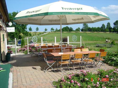 a table and chairs sitting under an umbrella at Heu-Ferienhof Altkamp in Putbus