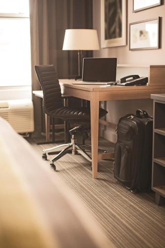 an office with a desk with a laptop and a suitcase at Country Inn & Suites by Radisson, Novi, MI in Novi