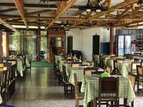 a dining room with tables and chairs in a building at Hotel Chicala salgar in Puerto Salgar