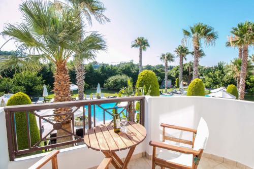 a balcony with a table and chairs and palm trees at Stavros Melathron Studios in Kallithea Rhodes
