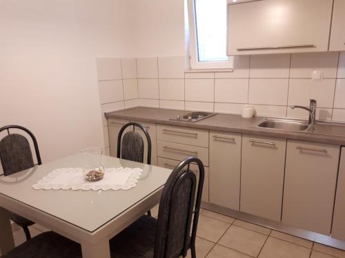 a kitchen with a table with chairs and a sink at Villa Marica in Neum