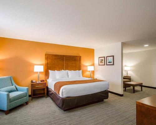 a hotel room with a bed and a blue chair at Comfort Inn in Ferdinand