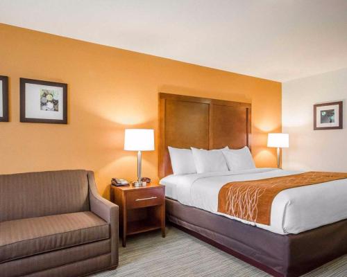 a hotel room with a bed and a chair at Comfort Inn Ferdinand in Ferdinand