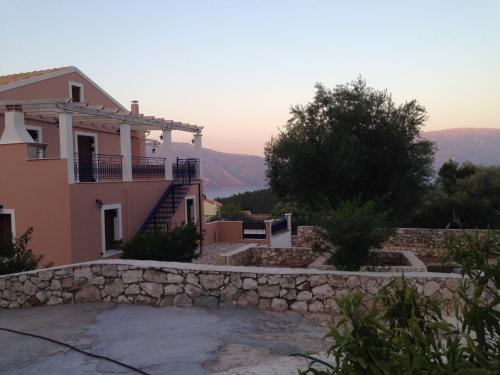 a house with a stone wall in front of it at Vila Tselentata in Fiskardho