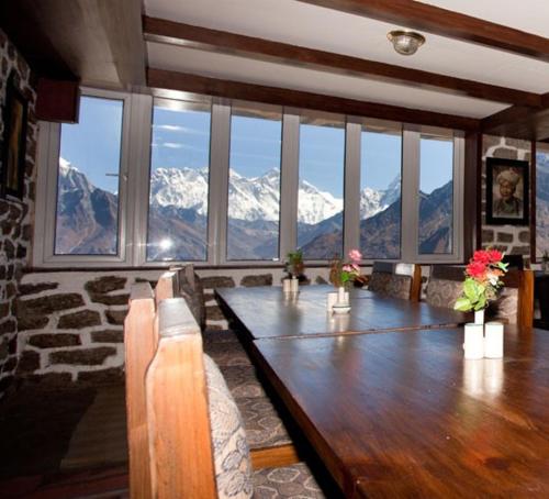 a dining room with a table with a view of mountains at Mountain Lodges of Nepal - Kongde in Kongde