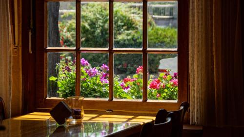 una ventana con vistas a una mesa y flores al aire libre en Hotel Haus Wagner, en Frechen