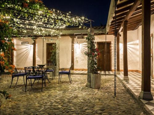 a patio with a table and chairs and lights at Casa Santamaria Hotel Campestre in Jericó