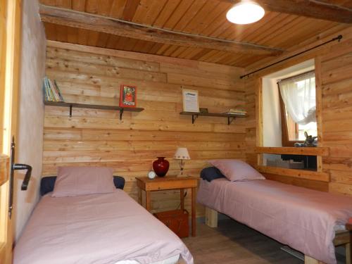 ヴァルドゥブロールにあるLa Maison de Josephineのベッド2台 木製の壁の部屋