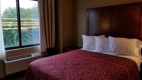 a hotel room with a bed and a window at Days Inn by Wyndham Brooklyn Marine Park in Brooklyn