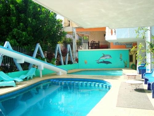 a swimming pool with a slide and a swimming pool at Suites Angelopolis in Acapulco