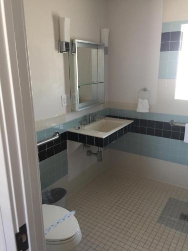 a bathroom with a sink and a toilet and a mirror at El Rancho Motel in Williams