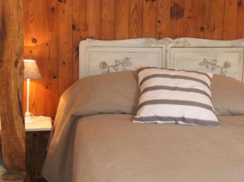 a bedroom with a white bed with a wooden wall at Ferme de la Cacheterie, in Fleury-la-Forêt