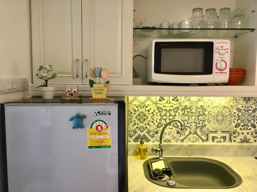 a kitchen with a sink and a microwave at Sandy Beach Condo 17D in Cha Am