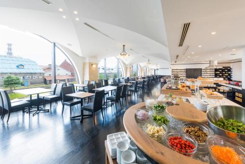 um restaurante com mesas e cadeiras com comida em Hotel Nord Otaru em Otaru