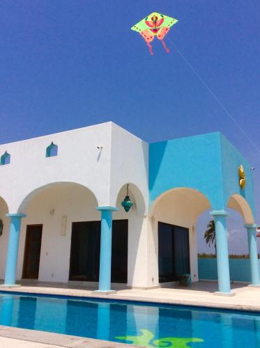 a kite flying in the sky over a pool at Villa Star of the Sea in Barra de Navidad