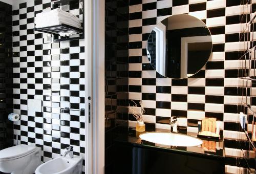 a bathroom with a black and white checkered wall at Residence Terminus in Rimini