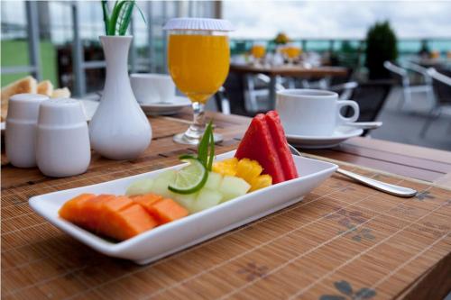 a plate of fruit on a table with a glass of beer at Hotel Luwansa Palangkaraya in Palangkaraya
