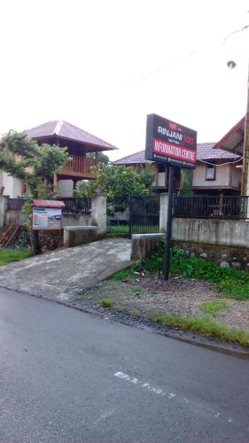 a sign on the side of a street with houses at Radiya Guesthouse in Sembalun Lawang