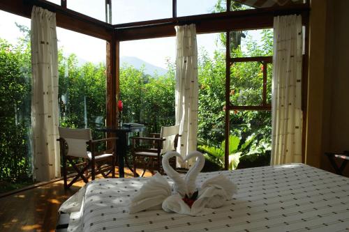 a bedroom with a bed with white towels on it at Tenorio Lodge in Bijagua